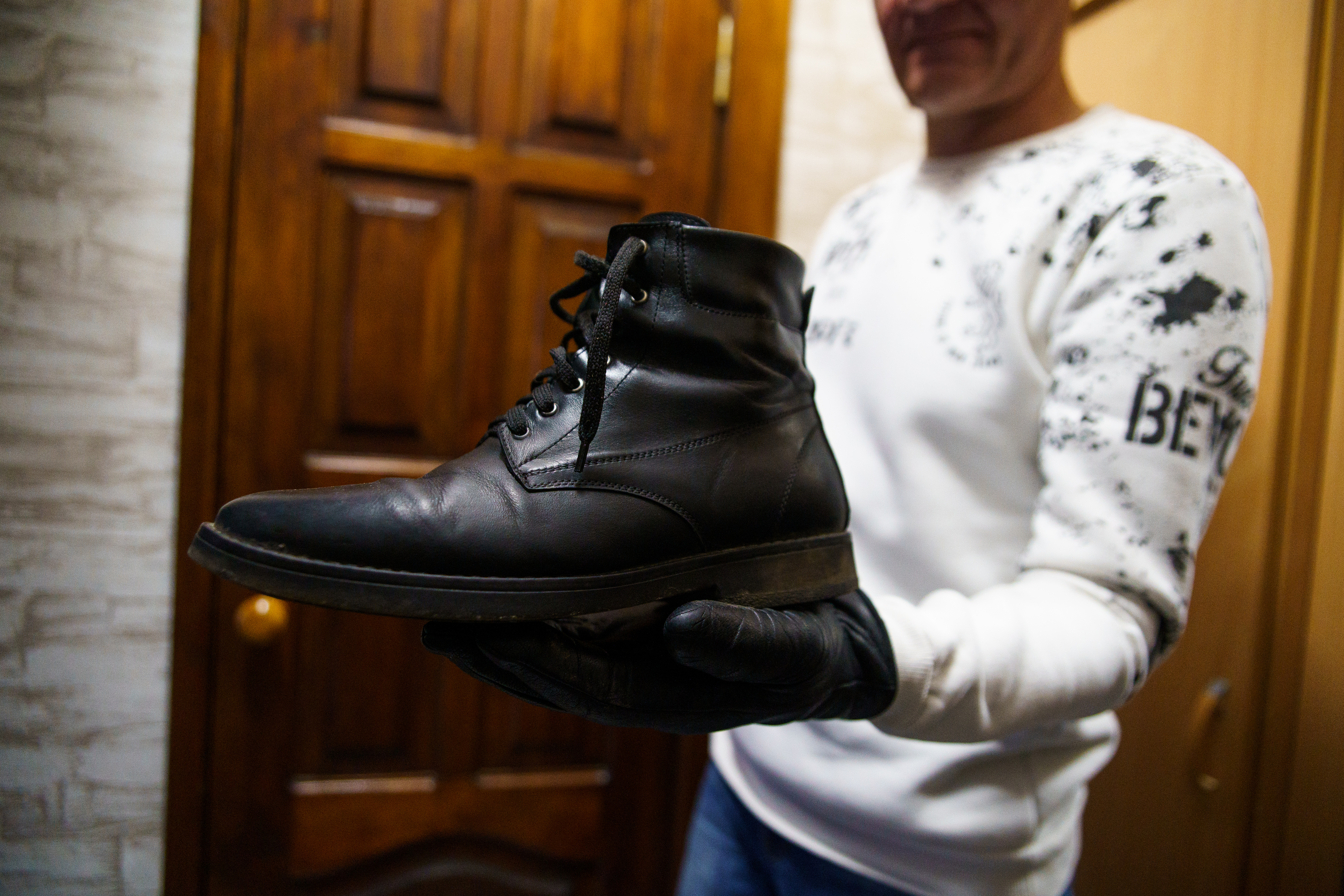 Taras shows a pair of shoes that he crafted for personal use.©DRC Ukraine, Chernihiv, February 2023, Volodymyr Cheppel.  