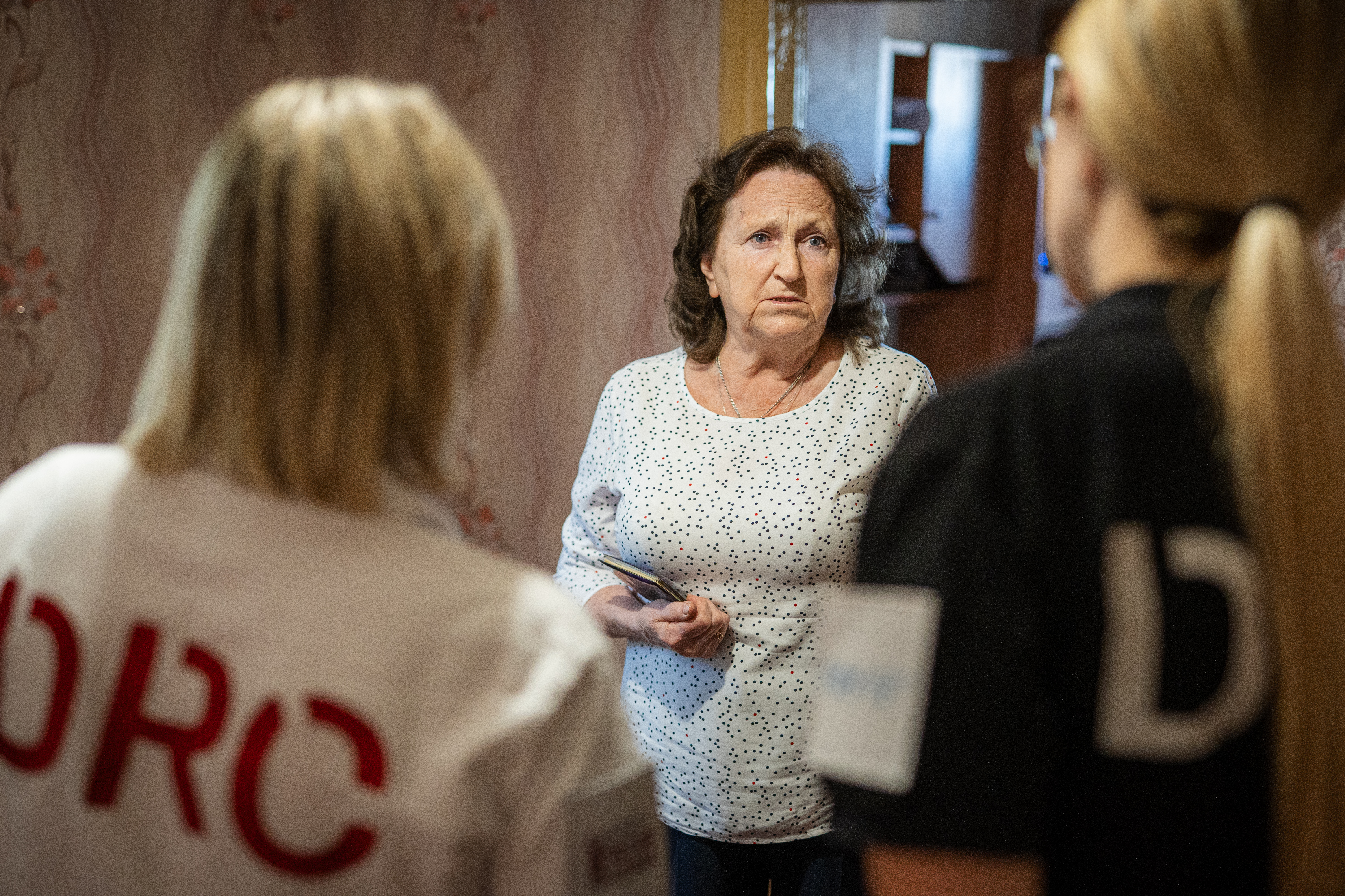 Liudmyla speaks with two DRC staff members during a visit in Kherson Oblast, Ukraine.