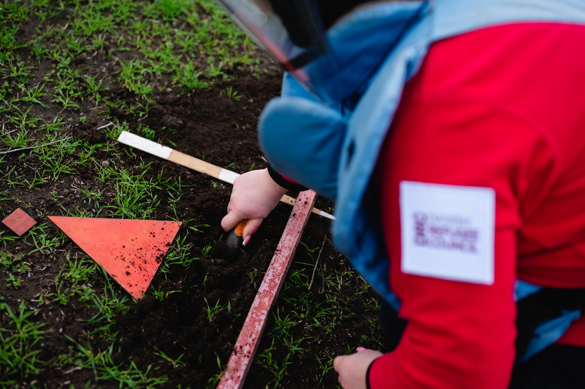 Deminers carefully excavate the soil by hand until they reach the source of the signal — potential explosive ordnance. ©DRC Ukraine, Kalynivka, Mykolaiv Oblast, November 2025, Svitlana Koval