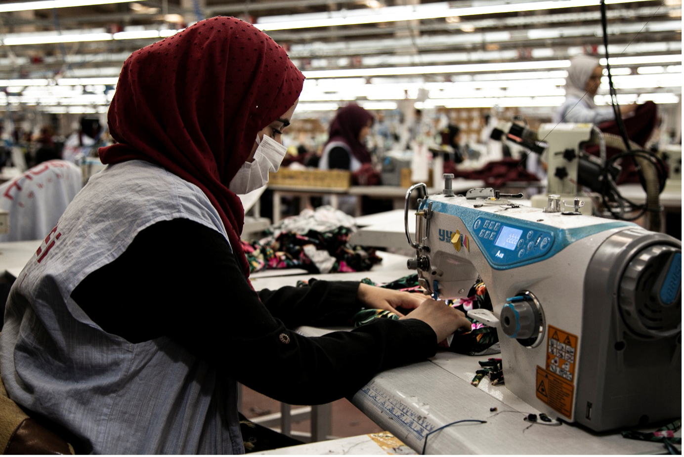 A participant of DRC Türkiye’s Wage Subsidy scheme in Şanlıurfa is at her workstation in a local garment factory. The programme supports both refugee and host community members in accessing formal employment.
