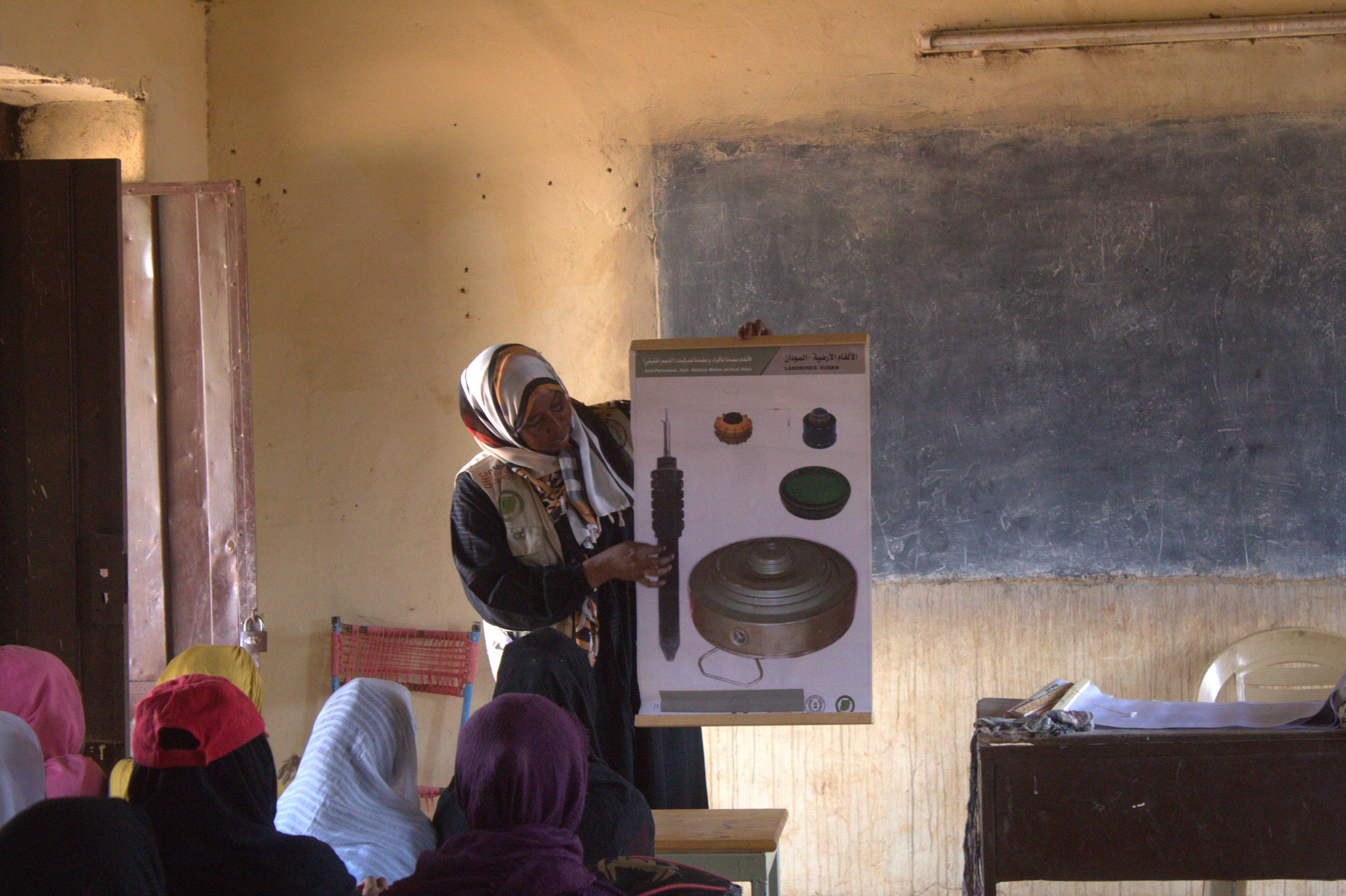 A Sudanese woman teach a class of children Explosive ordnance education awareness