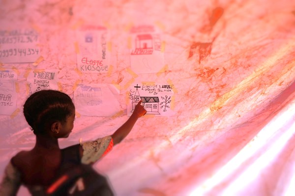 A child shows the drawing she made as part of an activity organized in one of the mobile child-friendly spaces (CFS) deployed during the activation of the Rapid Response Mechanism (RRM)